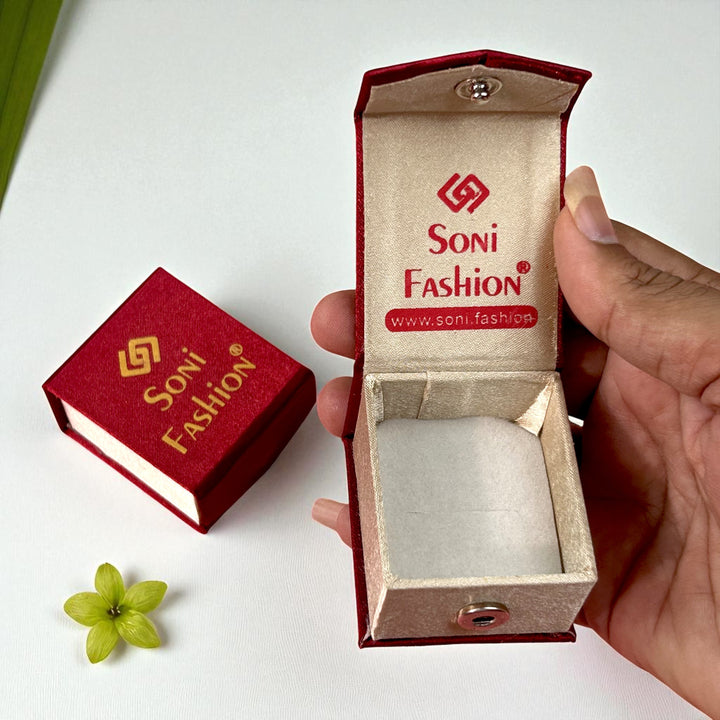 Red jewelry box with 'Soni Fashion' branding, held open by a hand on a white background.