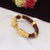 Close up of Lion With Diamond Fashionable Design Gold Plated Genda Kada bracelet on table