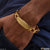 Gold plated bracelet for men with a close up of a hand wearing a gold bracelet